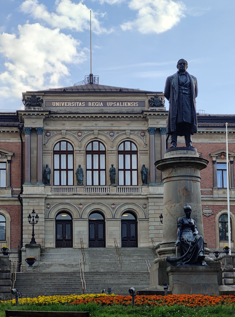 A photograph of the main building of the University of Uppsala in Sweden. It shows the big lettering on the front saying "IUniversitas Regia Upsaliensis" and a statue of historian and philisopher  Erik Gustaf Geijer