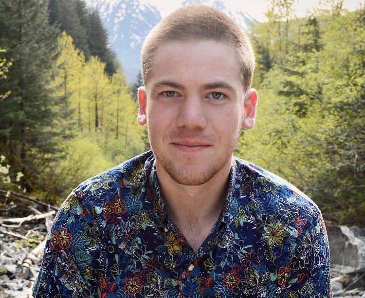 An image of Thomas Kauffman with trees and mountains in the background.