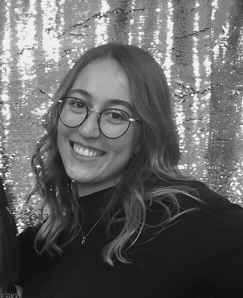 A black and white image of Rebecca Greenberg with a sequined backdrop