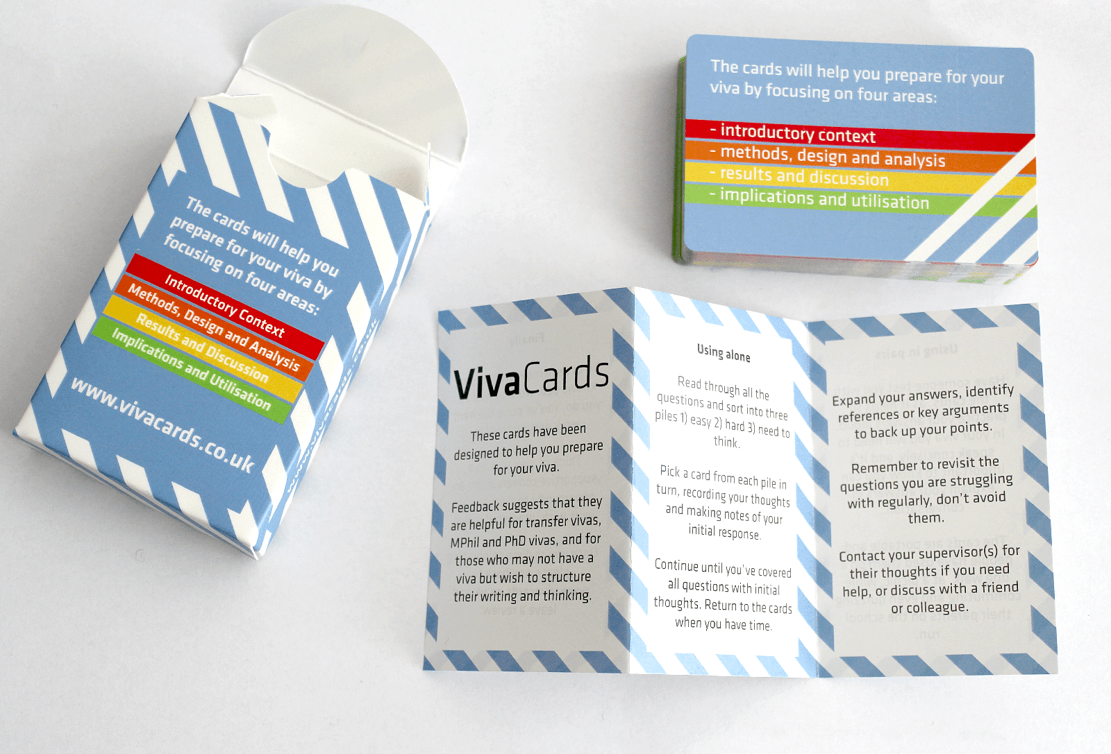 An open playing card sized box, next to it is a stack of playing card sizes cards and a small folded information and instruction leaflet