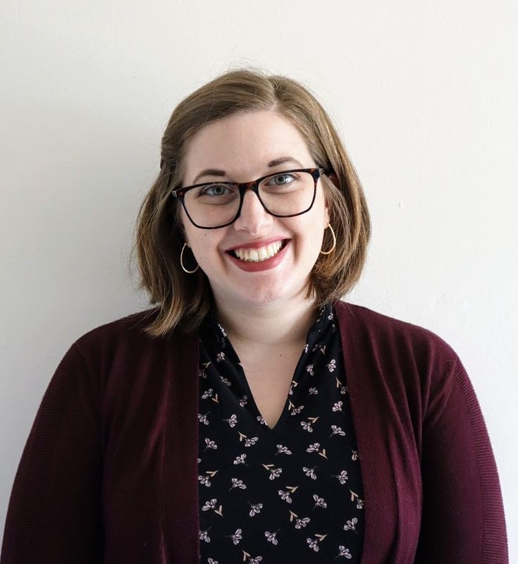 Picture of Rachel Kirby smiling. She is a young white woman with short light brown hair and dark glasses. 