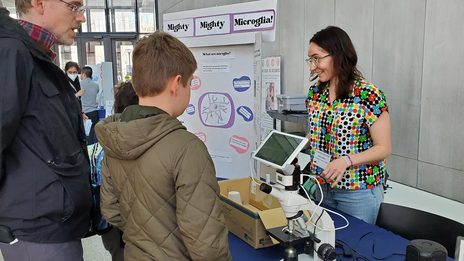 Guiding a student through Mighty, Mighty, Microglia! an interactive activity developed in the Science Communication Fellows Program at a Scientist Spotlight Event.