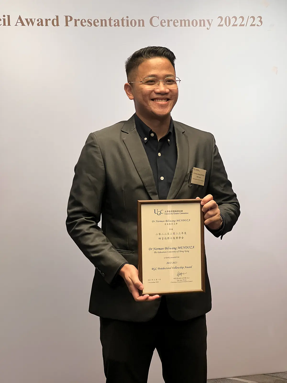 Dr. Mendoza happily receives the award certificate from UGC