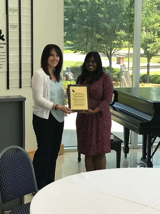 Dr. Caldorera-Moore presenting the Outstanding PhD Research Award on behalf of the department to Abitha Heimbuck (2018)