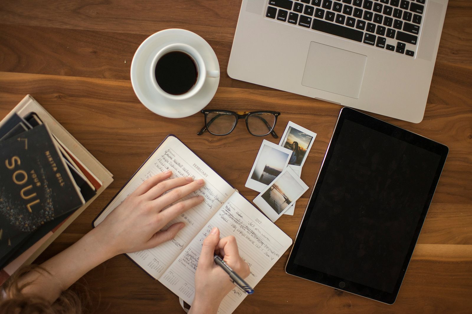 Notebook, coffee, and laptop on a wooden desk — illustrative image of scholarly writing.