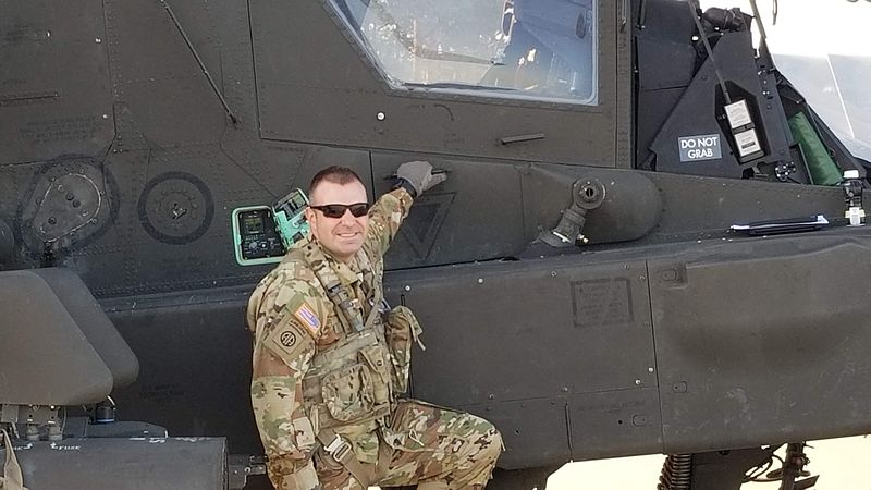 An image of Joshua Dawson next to a helicopter.