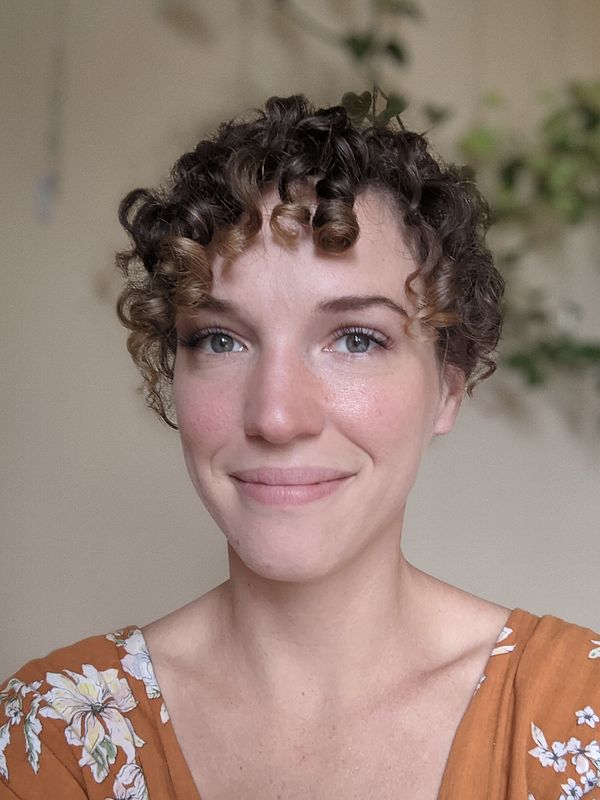 A headshot of Hannah Cohoon with plants visible in the background.