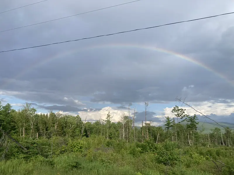 A break from rain in the field with a rainbow over Abenaki Land of the Wabanaki Nations, People of the First Light.