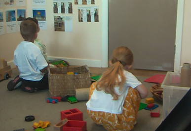 A girl and a boy playing in a construction area, neither child is acknowledging the other.