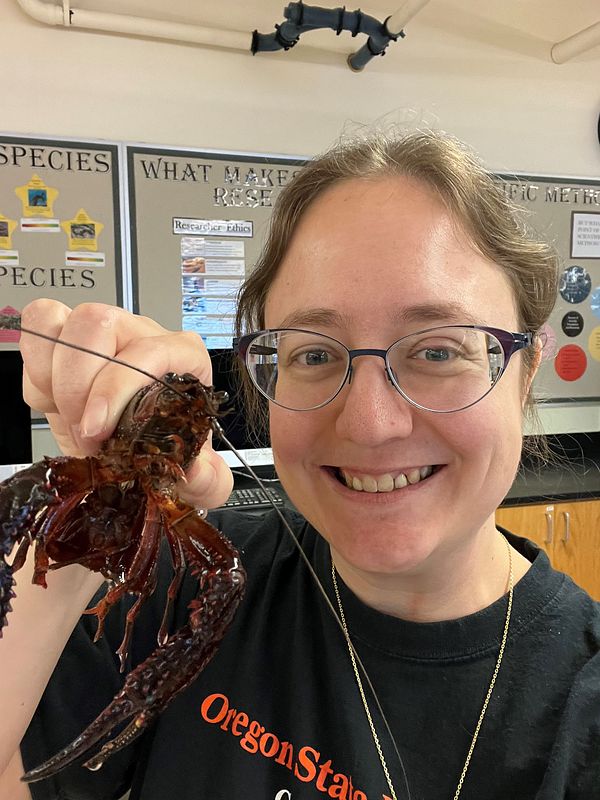 Smiling woman holds a large red crayfish