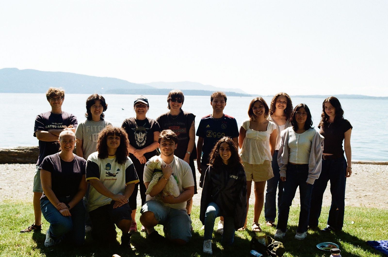 Team members lined up in two rows in front of Bellingham Bay