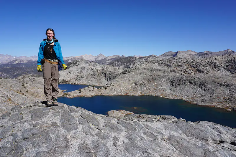 Juliet atop a special outcrop of mafic enclaves in Kings Canyon National Park—with more gabbro in view at Volcanic Lakes!!