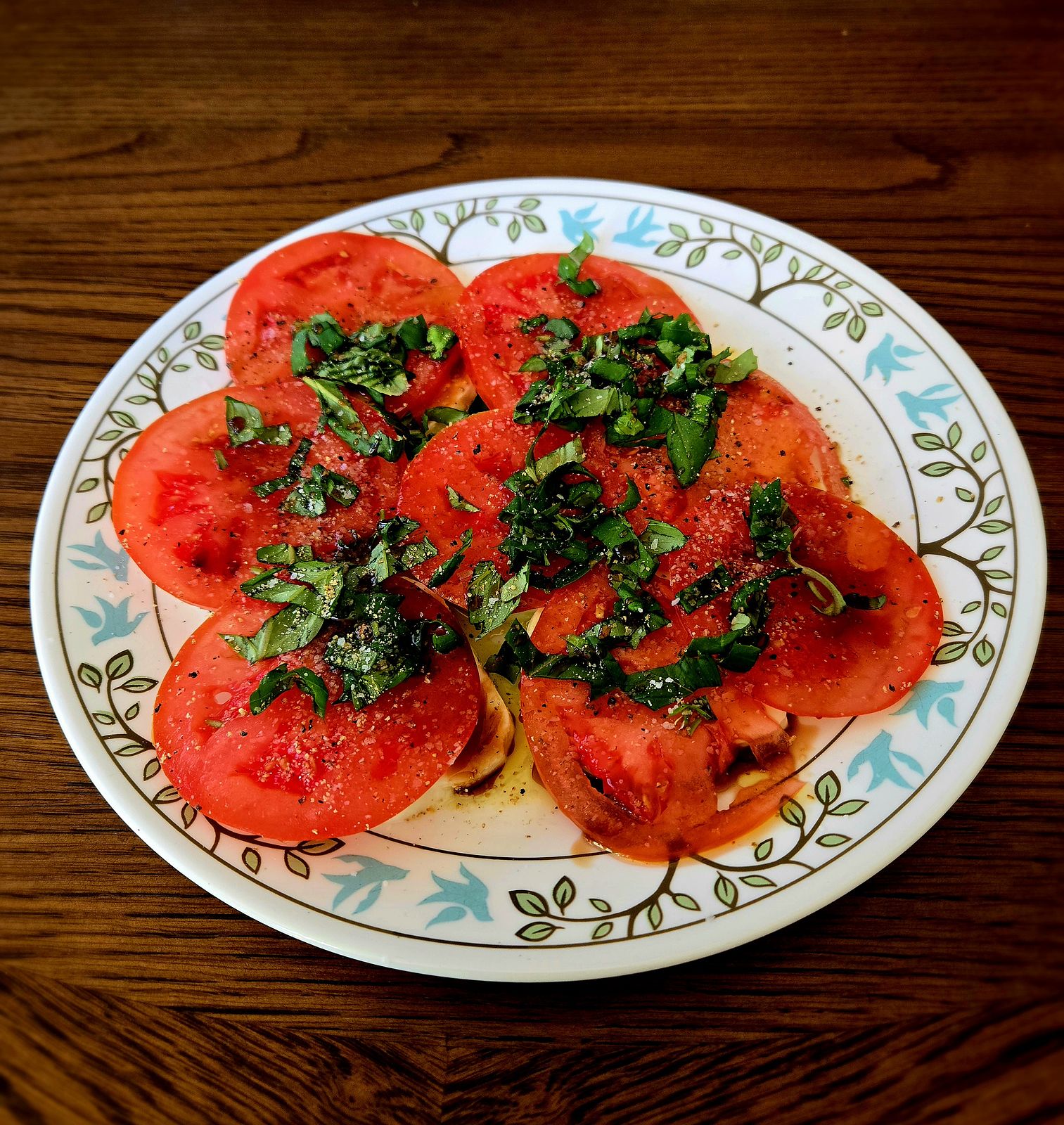 Caprese Salad with fresh basil in a plate on a wooden table.