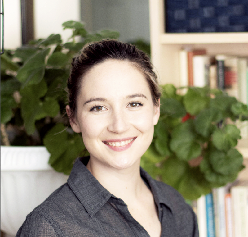 An image of Anna Bell with plants and books in the background