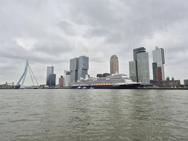 Netherlands, South Holland, Rotterdam (2025): Kop van Zuid with the MS Rotterdam of the Holland America Line and the Erasmus Bridge, seen from a Watertaxi on the Nieuwe Maas