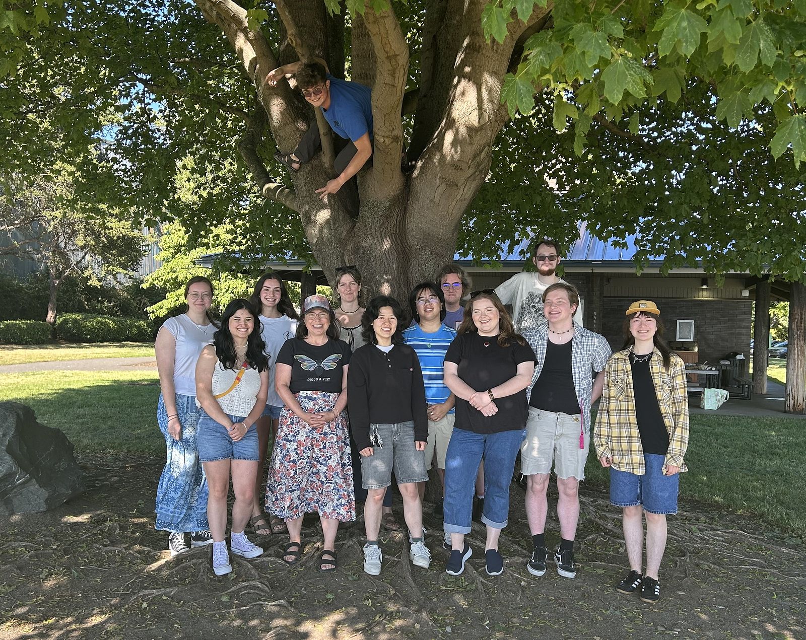 smiling team members gathered under a tree