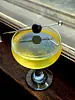 Orange Oracle in a coupe glass with Luxardo cherry garnish in the window sill.