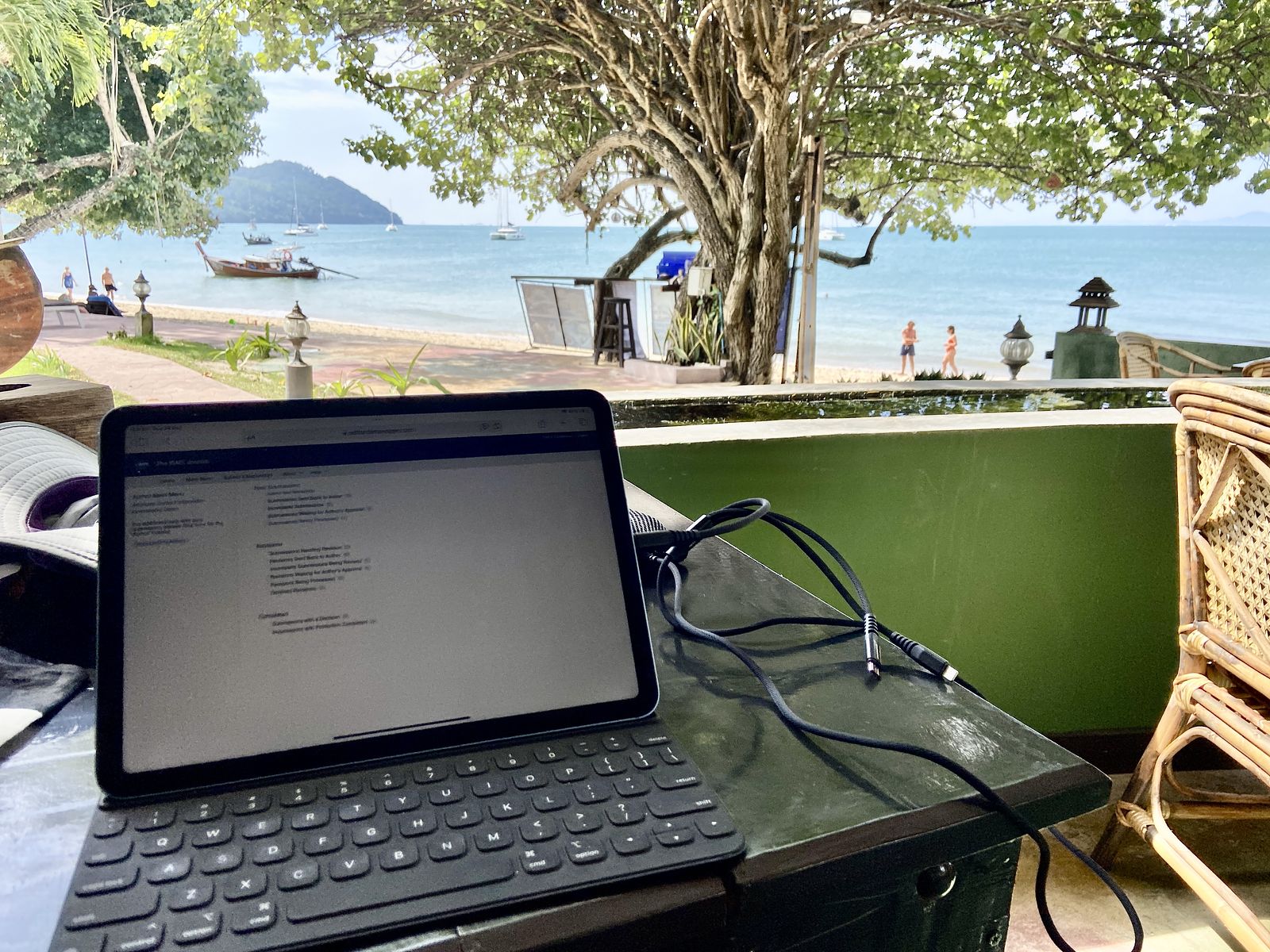 Tablet open to journal submission system on beach in Thailand